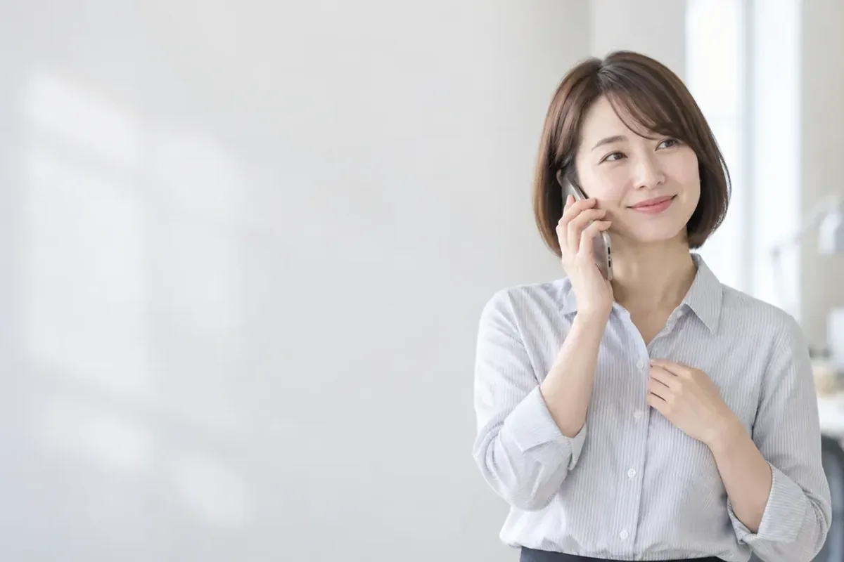 SKT 소액결제현금화 사무실 창가에서 휴대폰으로 통화하는 여성 24시 바로
